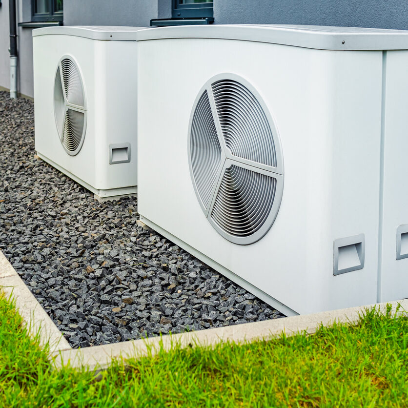 Two air source heat pumps installed outside of new and modern city house, green renewable energy concept of heat pump